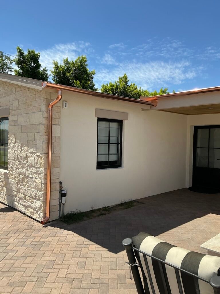 Six-inch copper half-round gutters and matching downspouts installed on a Phoenix-area home